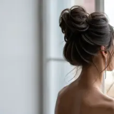 Elegancki, luźny kok na dole, ozdobiony długimi kolczykami, tworzy subtelny look.