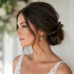 Eleganckie fryzury na wesele z grzywką, jak ta romantyczna upięta fryzura panny młodej, dodają uroku.
