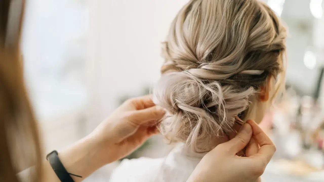 Eleganckie fryzury na wesele dla włosów średnich, idealne dla gościa po 40-tce. Upięcie z subtelnymi lokami.