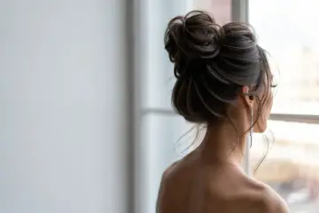 Elegancki, luźny kok na dole, ozdobiony długimi kolczykami, tworzy subtelny look.